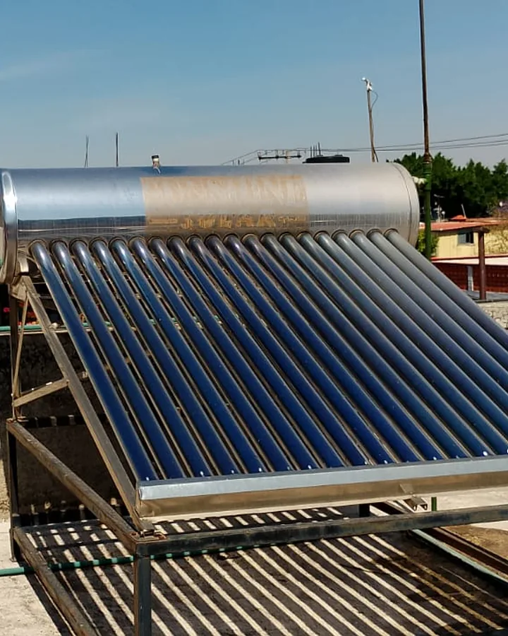 Calentador solar de tubos al vacío en la azotea de una casa