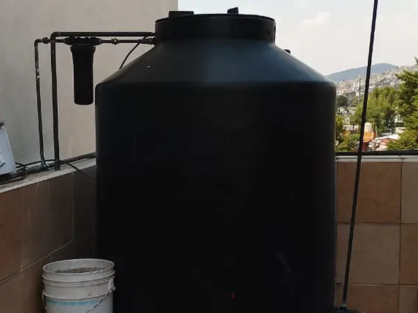 Tinaco negro en una azotea con su filtro de entrada
