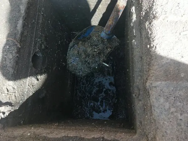 Pala sacando lodo del fondo de una cisterna