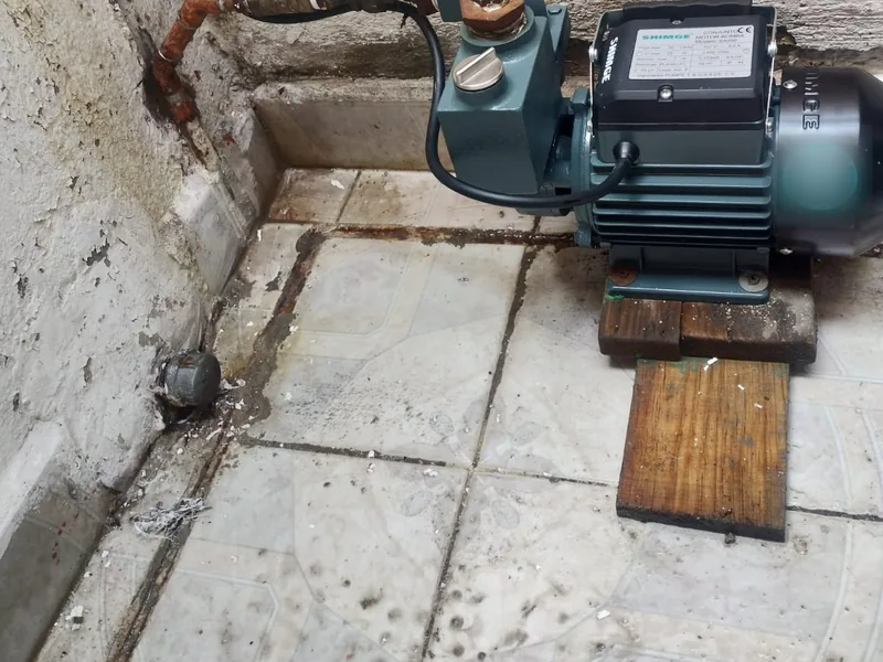 Bomba de agua periférica instalada en un patio con su tubería de cobre