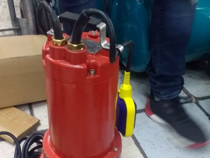 Bomba sumergible roja con flotador amarillo lista para instalar