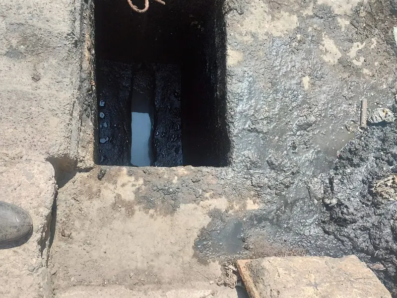 Registro de drenaje abierto con lodo antes del desazolve