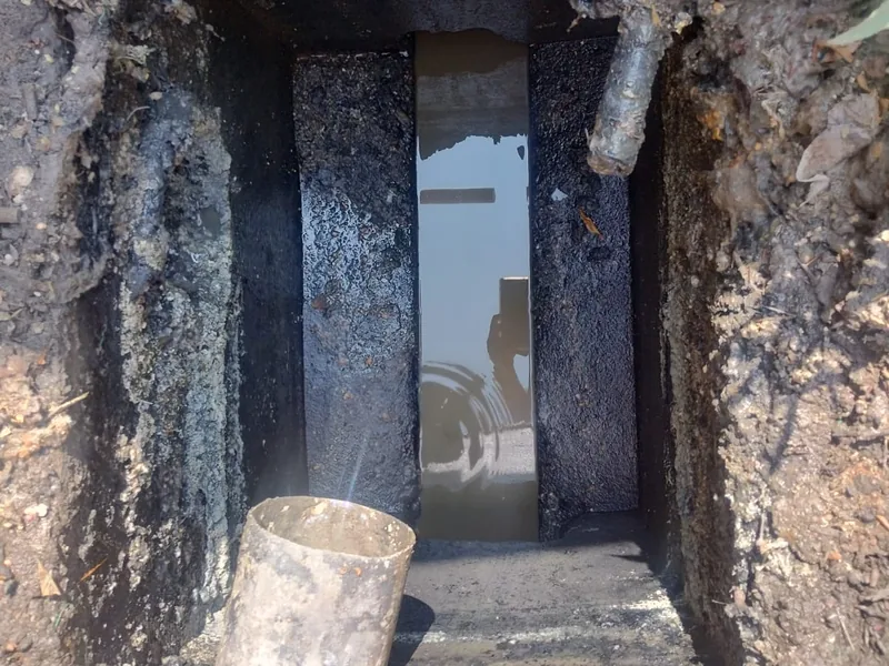 Registro excavado con la tubería principal descubierta para desazolvar
