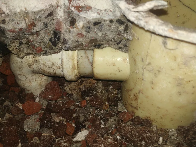 Tubería de PVC descubierta en una excavación pequeña después de la detección de fuga de agua