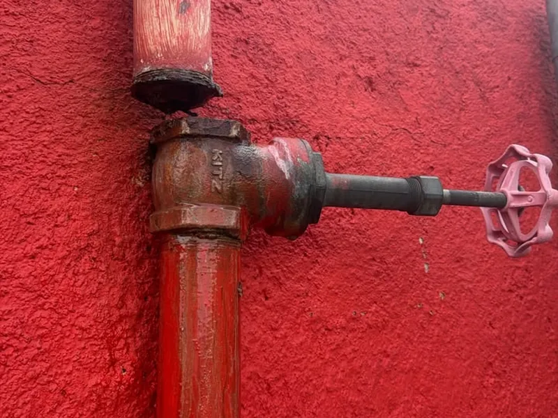 Tubería y válvula de paso revisadas en un muro exterior