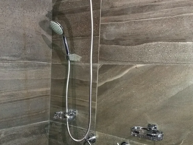 Regadera y mezcladoras instaladas en un baño remodelado
