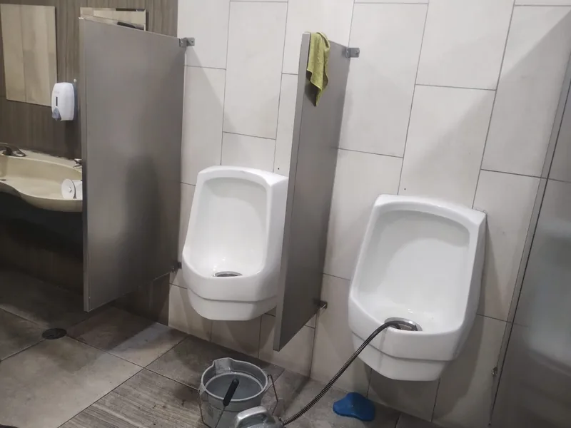 Mingitorios de un negocio con la sonda trabajando durante una urgencia de plomería